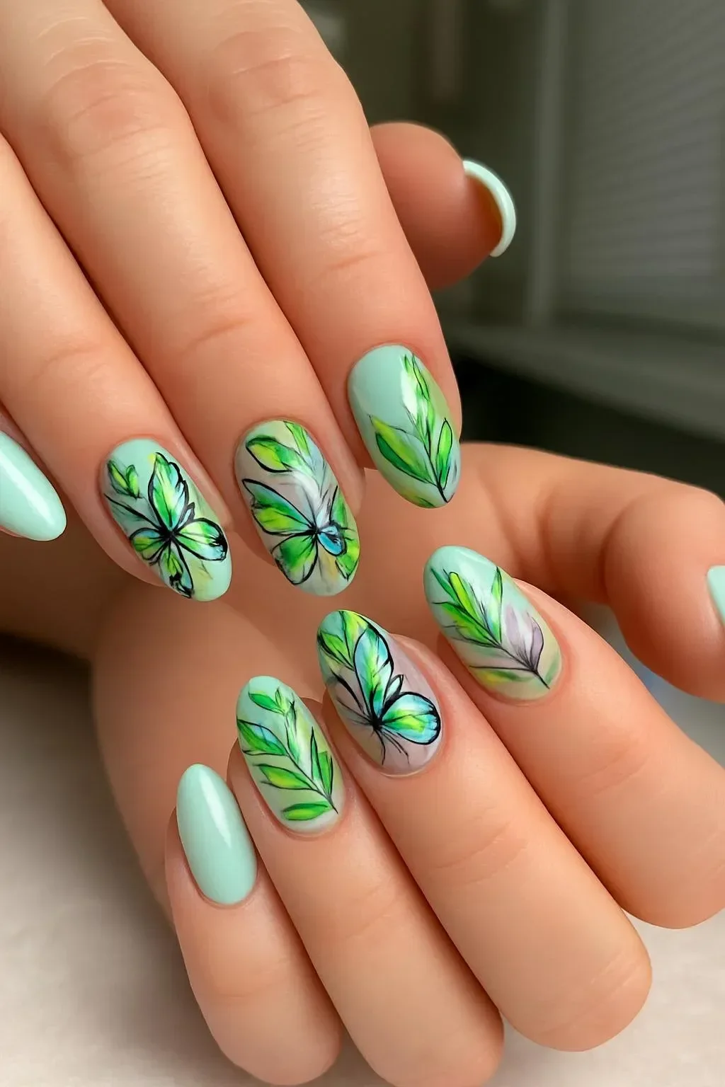 Mint green almond nails with hand-painted floral art for spring 2026 trends