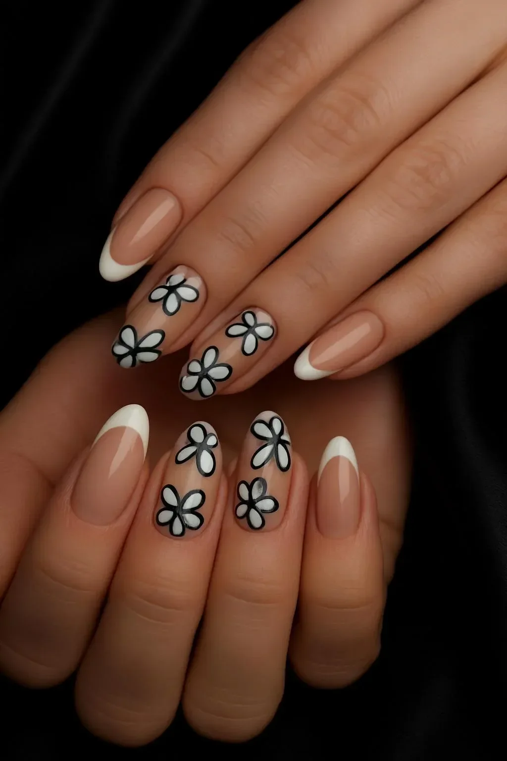 Nude almond nails featuring white daisy French accent designs for spring 2026.