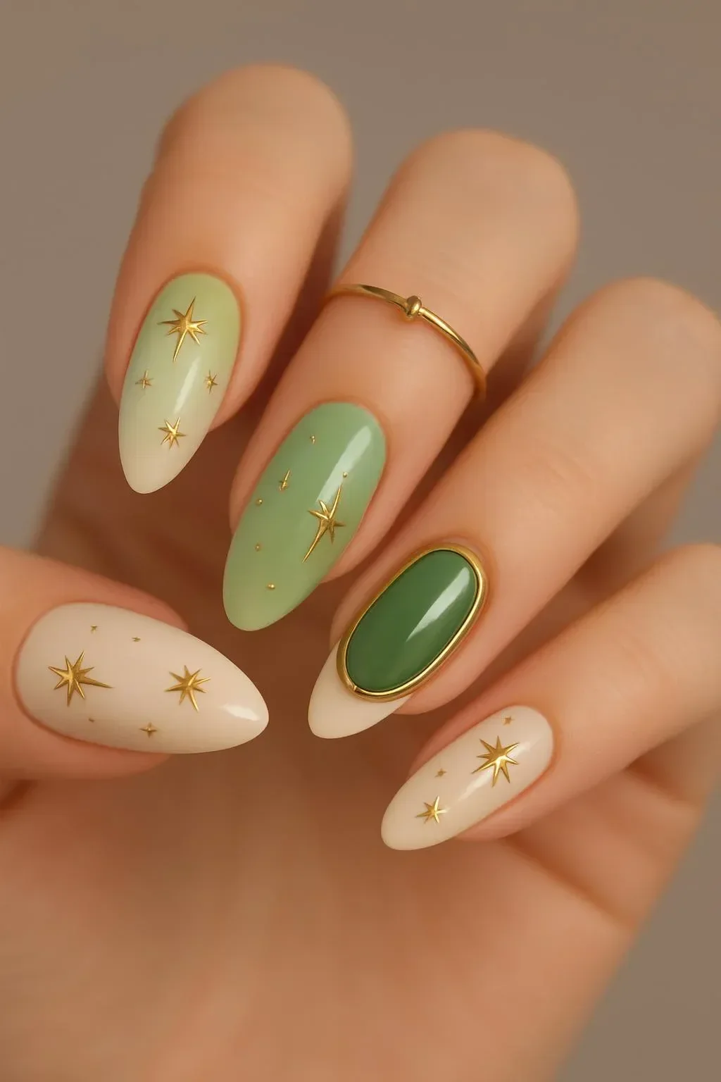 Woman showing off stylish olive green nails with chrome and gold accents