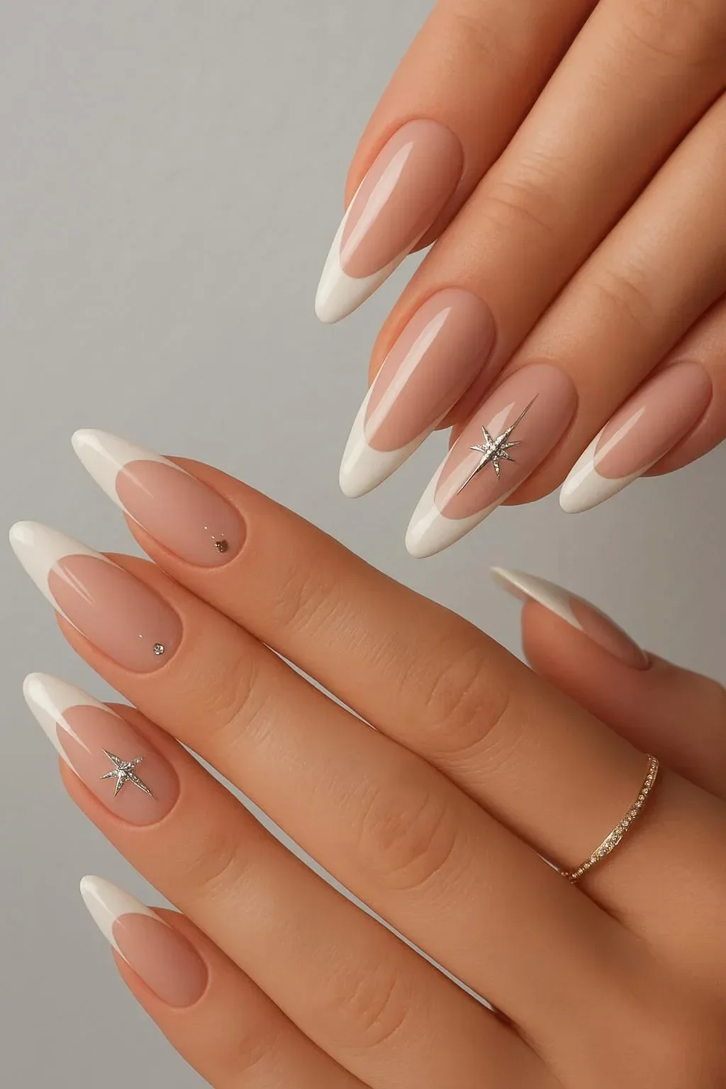 Nude and white French tips nails with star rhinestones design.