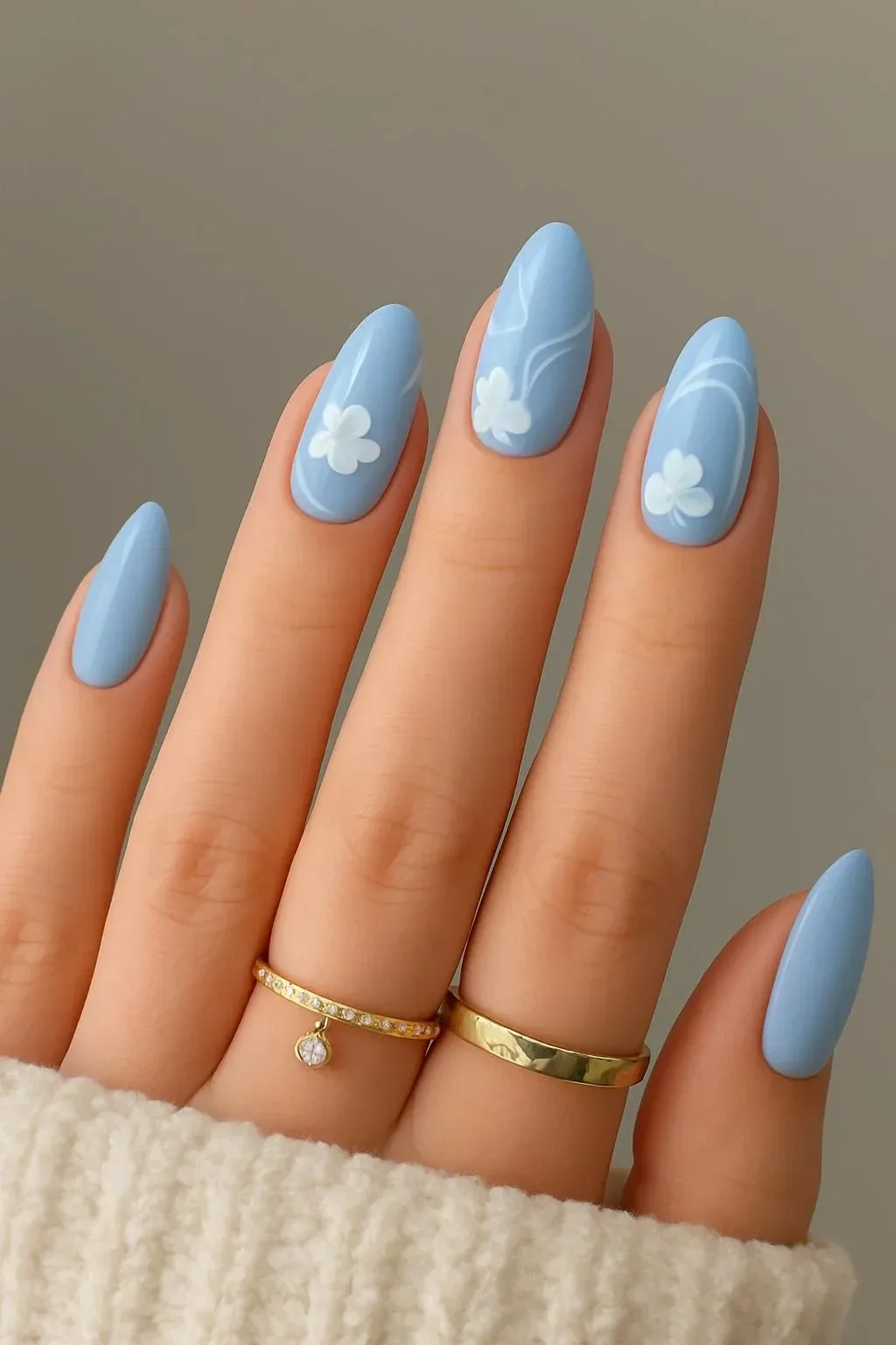 Beautiful floral designs on gel nails with blue and white swirls for a beach look.