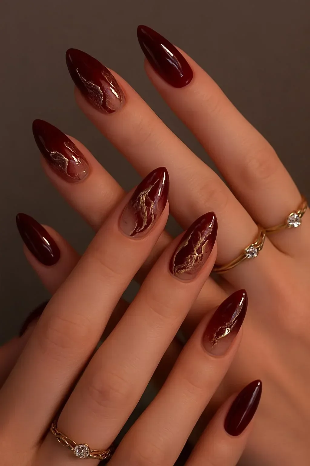 Burgundy nail art design with gold details for an elegant appearance