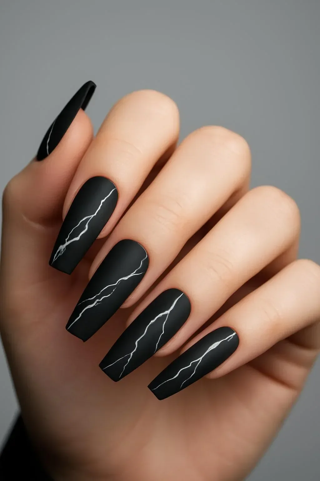 Matte black marble long almond and stiletto nails design