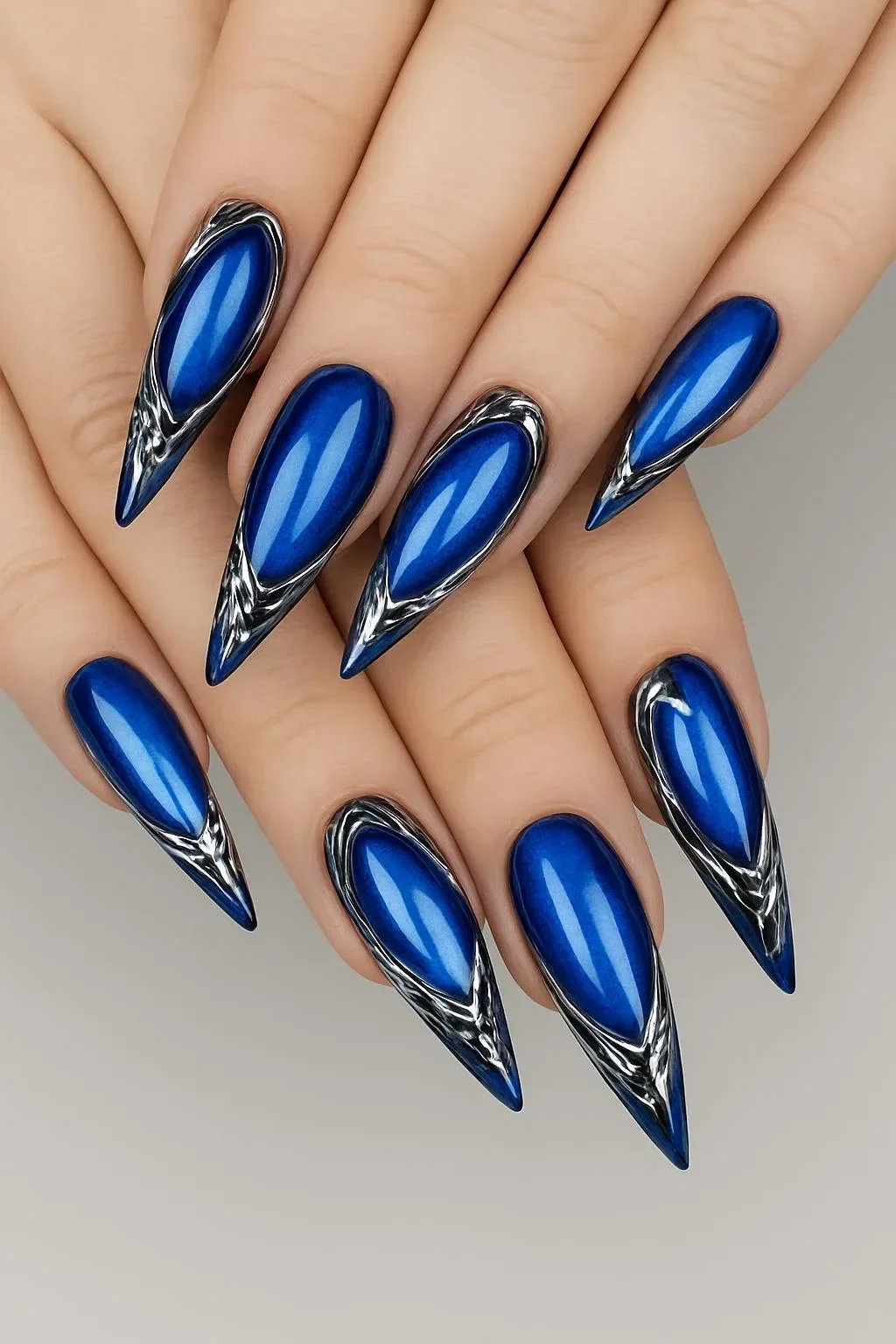 Deep blue cat-eye nails with liquid chrome details for artistic nail design
